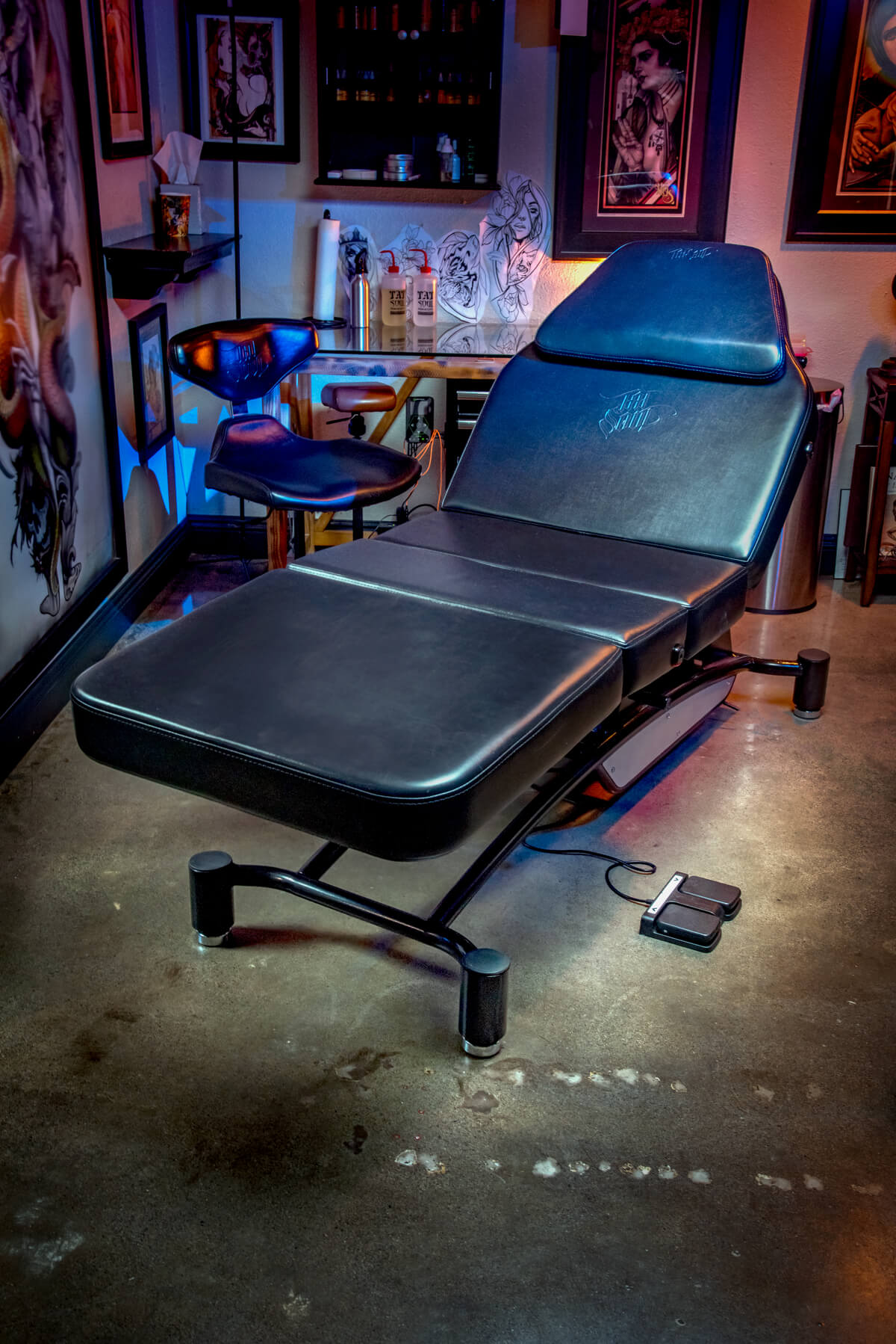 The Oros battery operated tattoo bed in a tattoo studio to demonstrate its adjustment, versatility and comfort for the artist and client